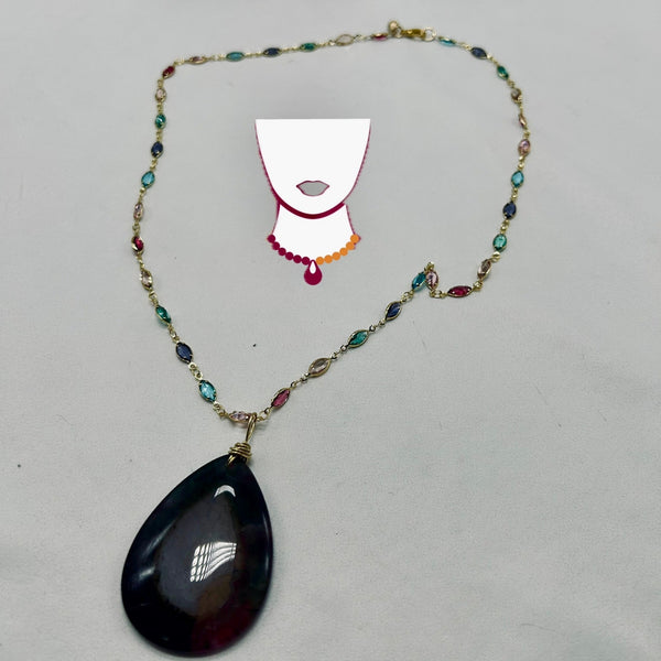 Necklace with a black teardrop pendant on a gray background