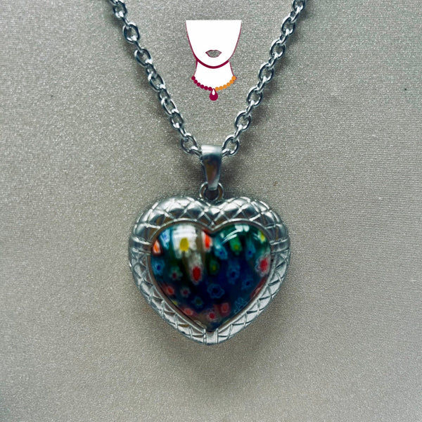 Heart-shaped pendant with colorful design on a chain against a gray background
