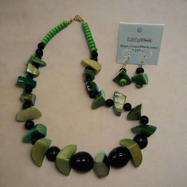 Green and black beaded necklace and earrings with a label on a white background