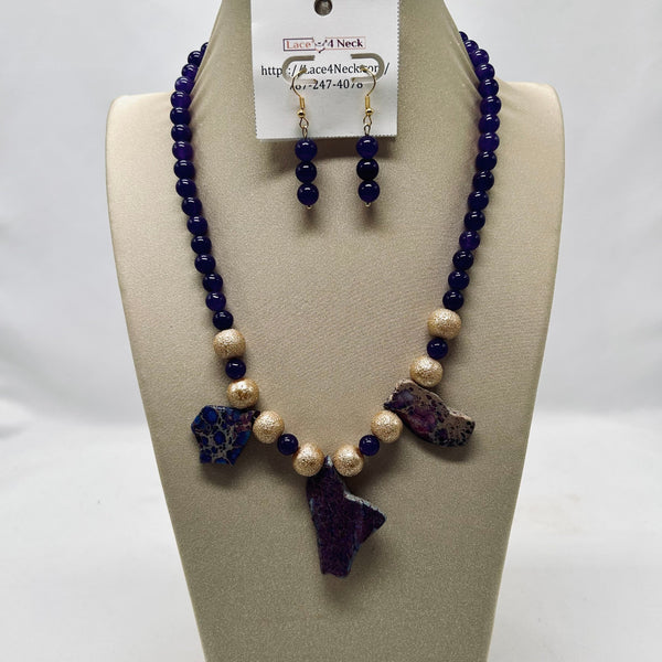 Necklace and earrings set on a mannequin bust with a visible brand tag.