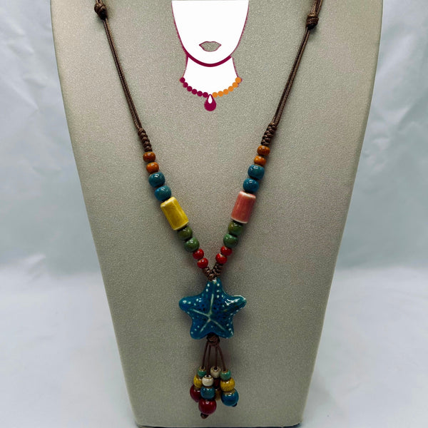 Necklace with star-shaped pendant and colorful beads on a gray stand.