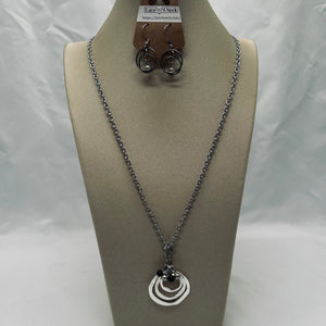 Necklace and earrings on a mannequin bust with a white background