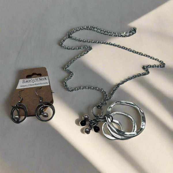 Silver necklace with circular pendants on a light surface