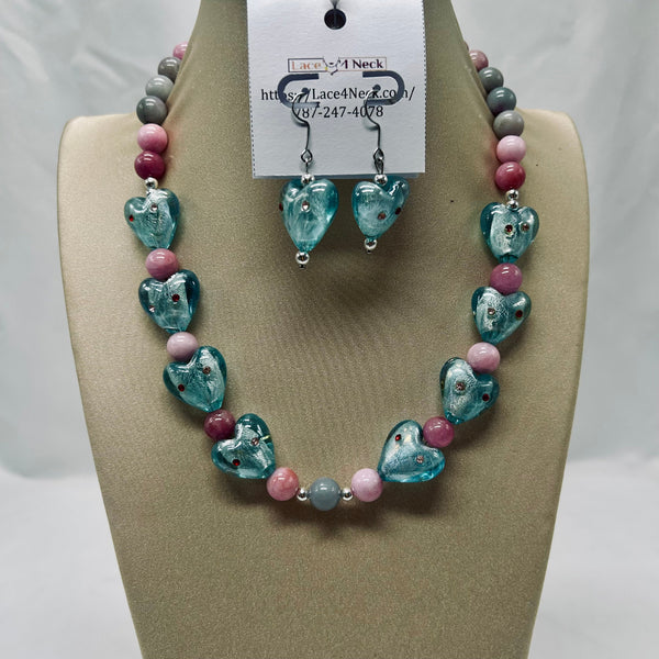 Necklace and earrings set on a tan display with a visible brand tag.