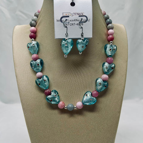 Necklace and earrings set on a tan display with a visible brand tag.