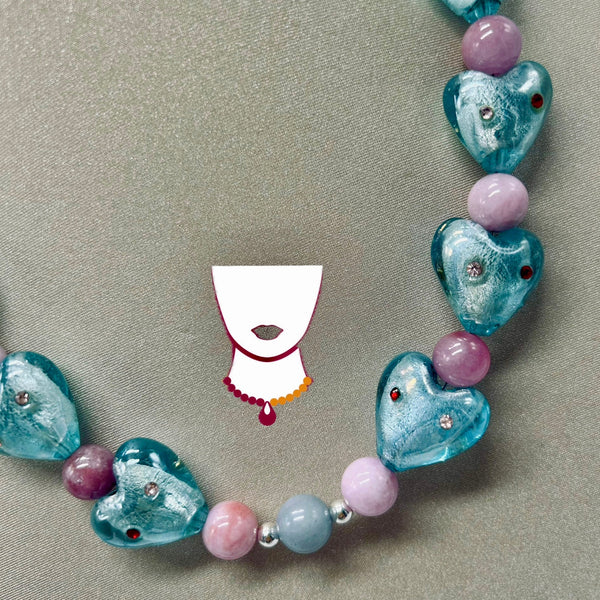 Necklace with blue heart-shaped beads and pink spherical beads on a beige background