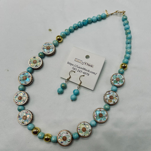 Necklace and earrings set with decorative beads on a gray background