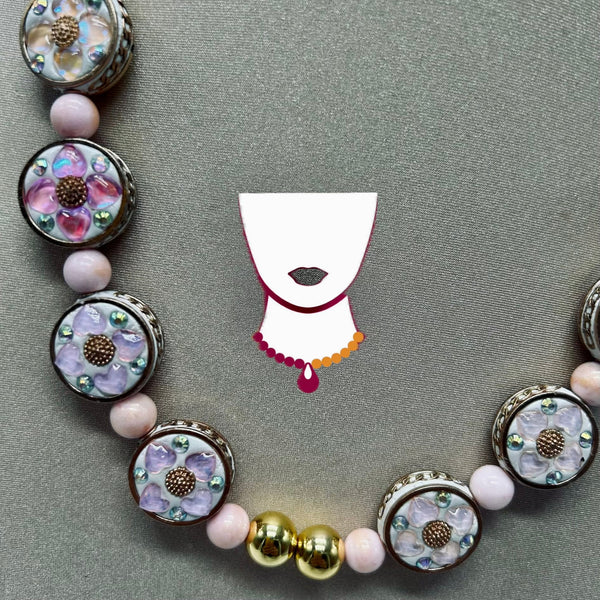 Necklace with pink and purple hearts over white resin.