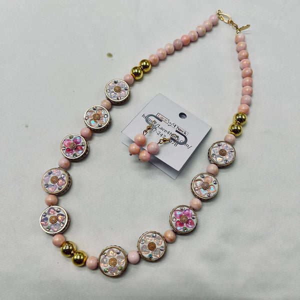 Necklace with pink and gold beads on a light gray background