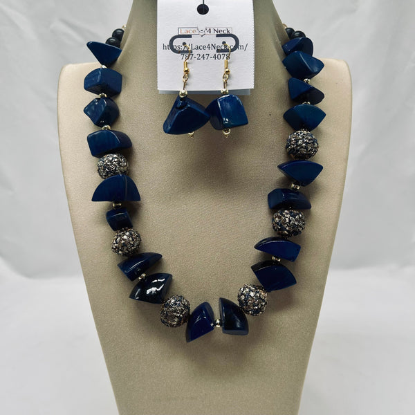 Necklace and earrings set with blue and silver beads on a beige display card.