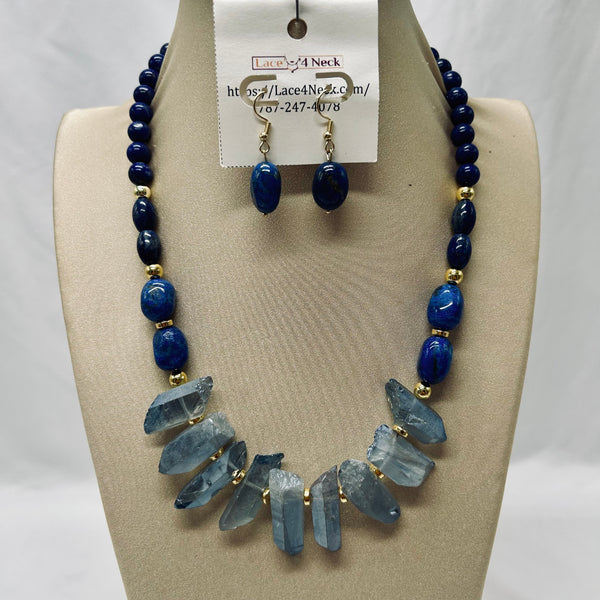 Jewelry set with necklace and earrings on a mannequin bust, featuring blue beads and crystal-like elements.