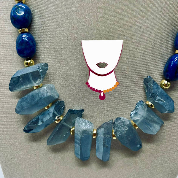 Necklace with blue crystal-like beads and gold accents on a neutral background