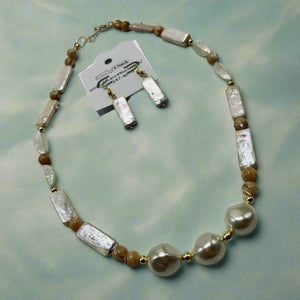 Necklace with white and brown beads on a gray surface, accompanied by matching earrings and a card.