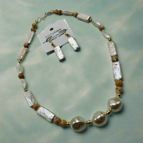 Necklace with white and brown beads on a gray surface, accompanied by matching earrings and a card.