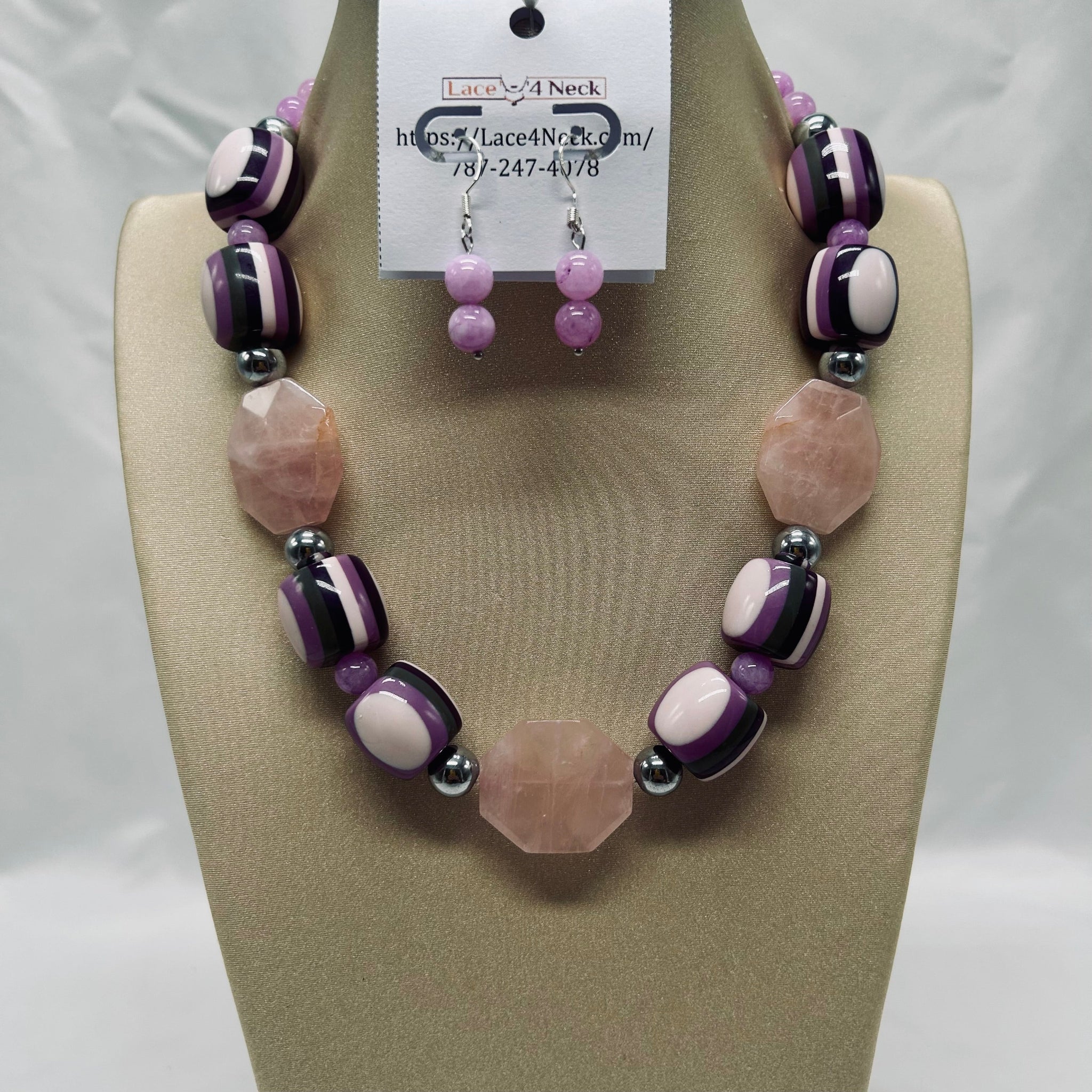 Necklace and earrings set on a mannequin with a visible brand tag.
