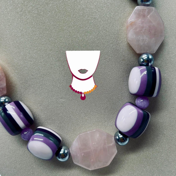 Necklace with purple and white beads on a gray background