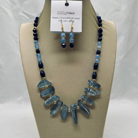 Necklace and earrings set with blue beads on a beige stand
