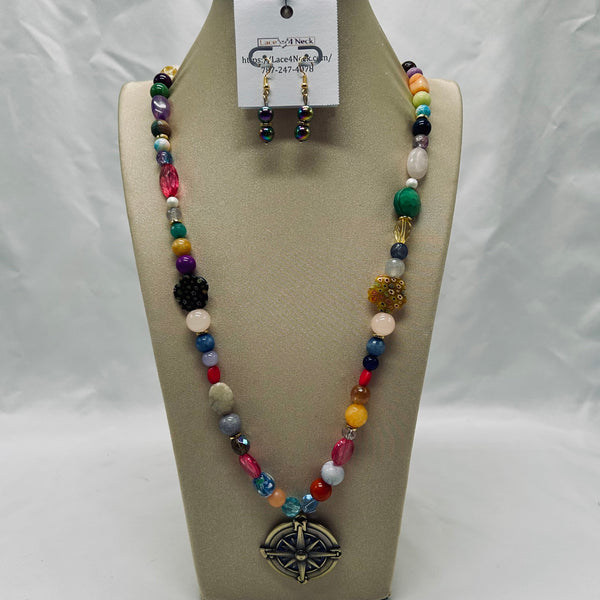 Colorful beaded necklace and earrings on a tan display stand with a white background
