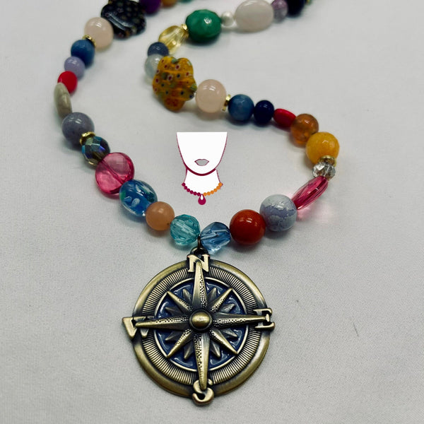 Necklace with colorful beads and a compass pendant on a light gray background