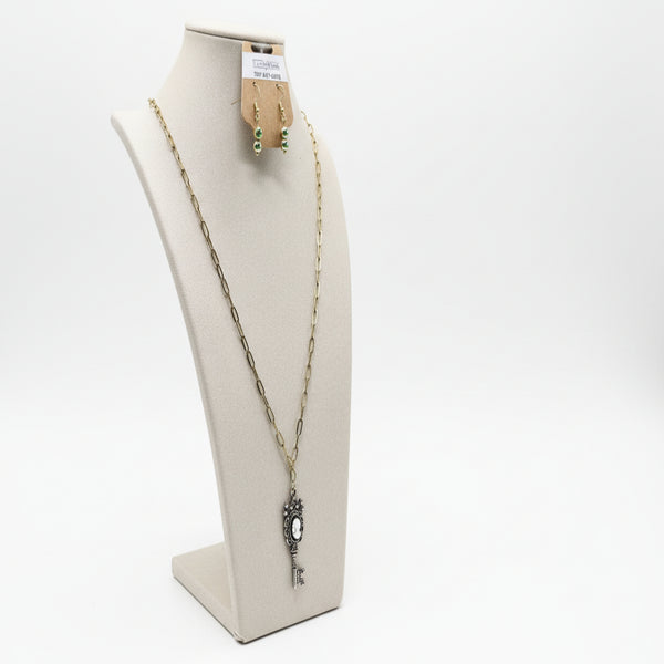 Necklace and earrings on a mannequin bust with a green background
