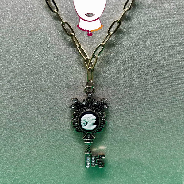 Necklace with a key-shaped pendant featuring a cameo design on a gray background