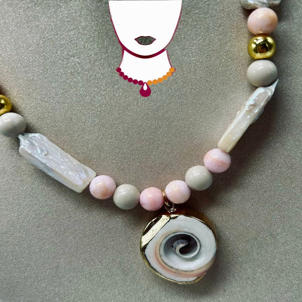 Necklace with pink, white, and gold beads on a gray surface