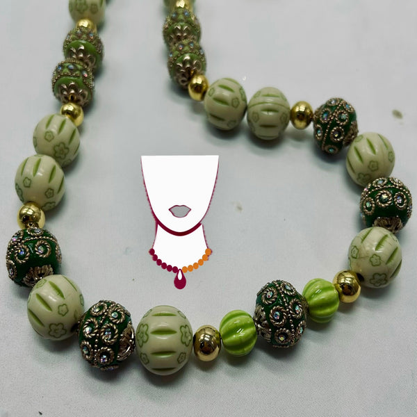 Necklace with green and gold beads on a white background