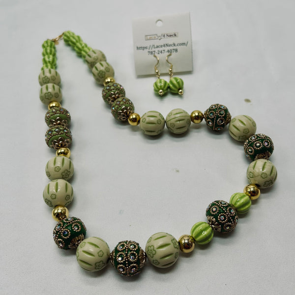 Necklace and earrings set with green and gold beads on a white background