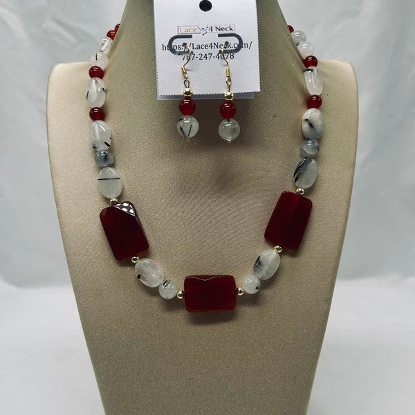 Necklace and earrings set on a mannequin bust with a visible brand tag.