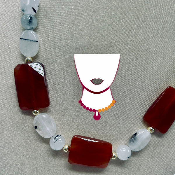Necklace with red and white beads on a gray background