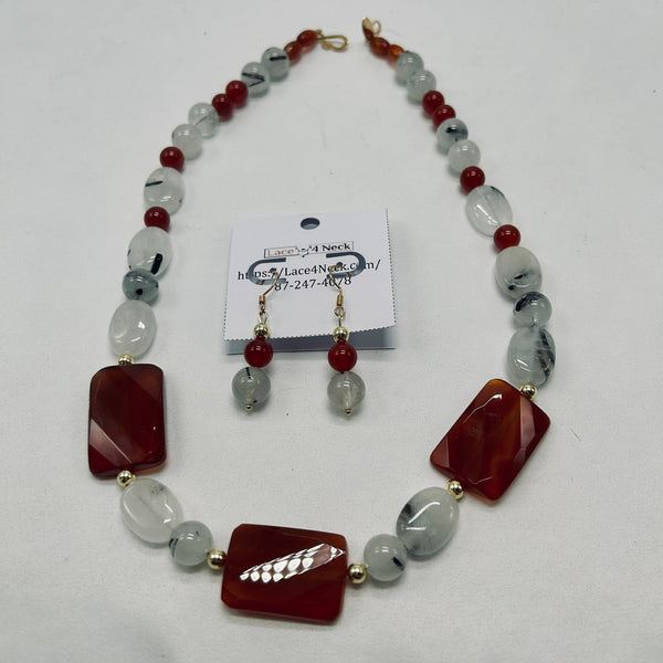 Beaded necklace with red and clear beads on a white background