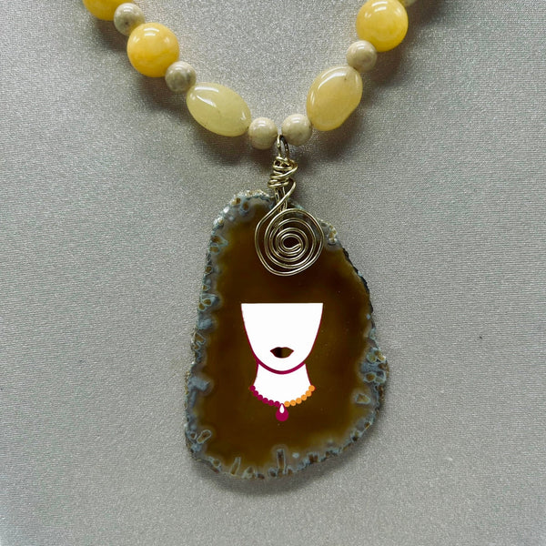 Necklace with a pendant featuring a face design on a gray background