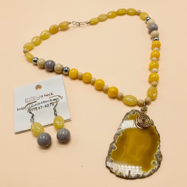 Necklace with yellow and gray beads and a large pendant on a white background