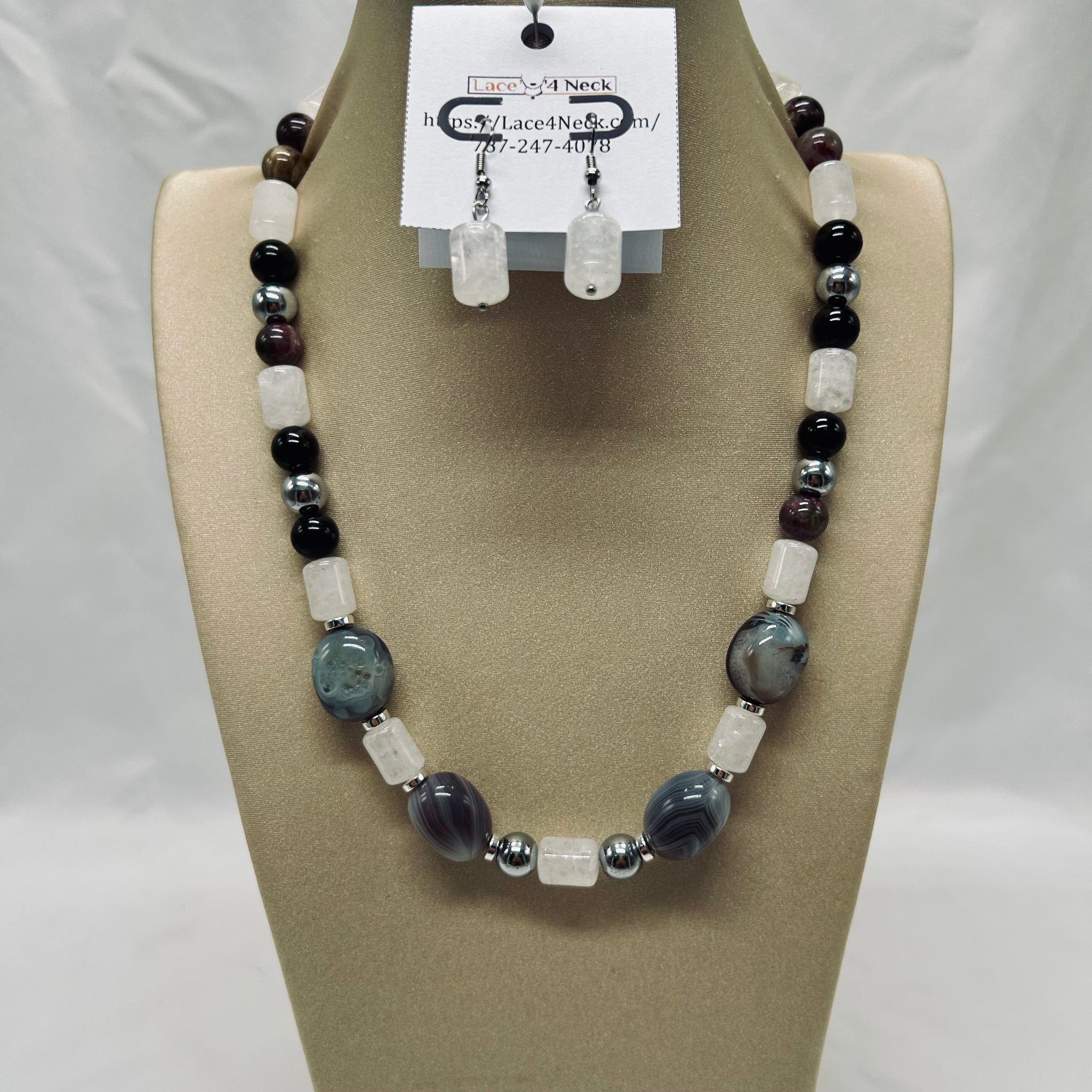Beaded necklace and earrings on a mannequin bust with a visible brand tag.