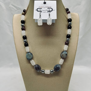 Beaded necklace and earrings on a mannequin bust with a visible brand tag.