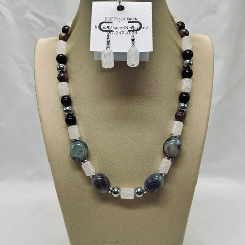 Beaded necklace and earrings on a mannequin bust with a visible brand tag.