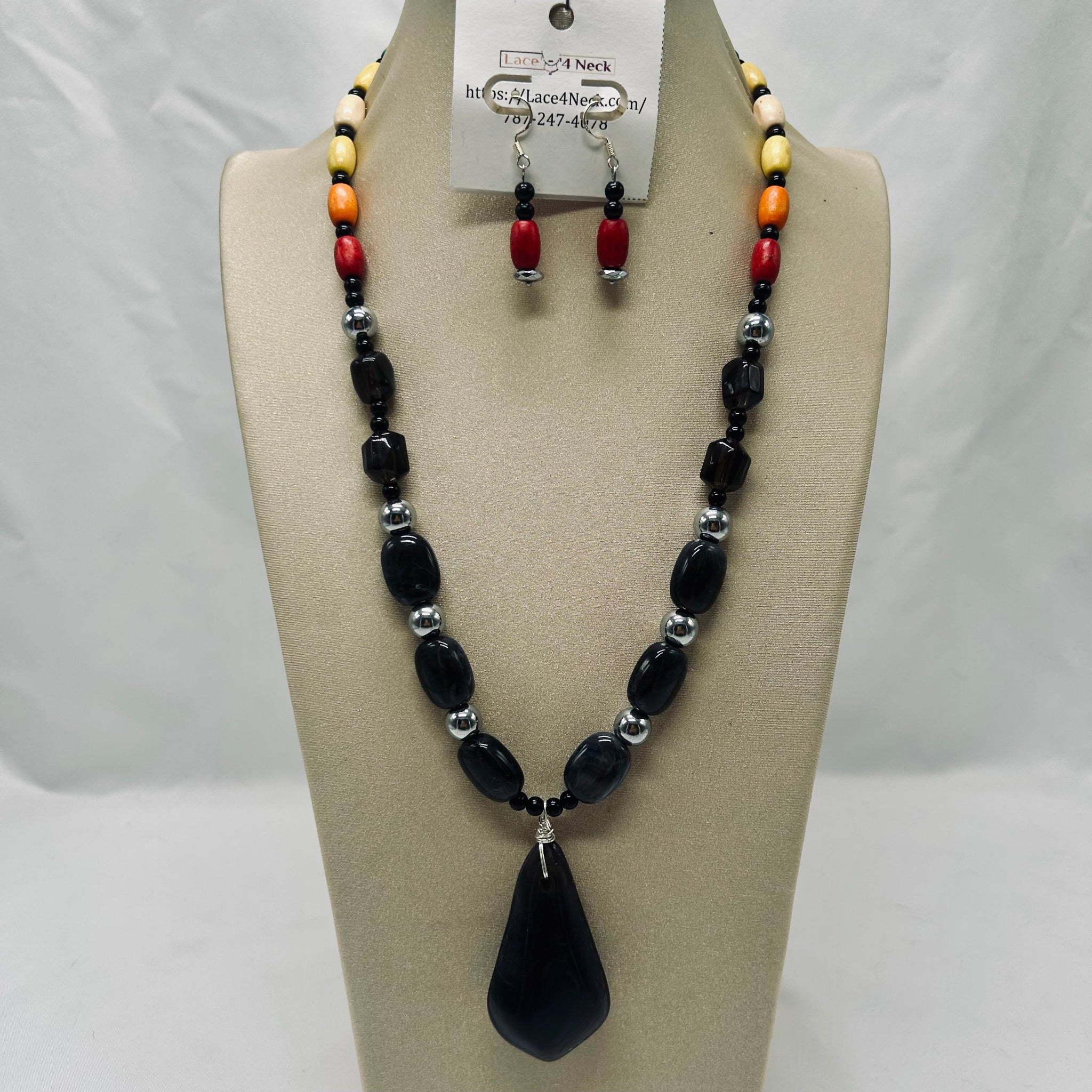 Beaded necklace and earrings set on a mannequin bust with a white background