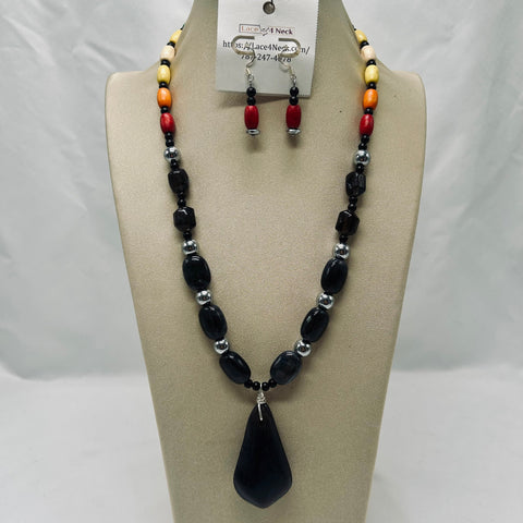 Beaded necklace and earrings set on a mannequin bust with a white background