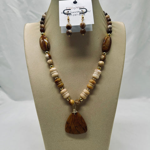 Beaded necklace with a large brown pendant on a display stand.
