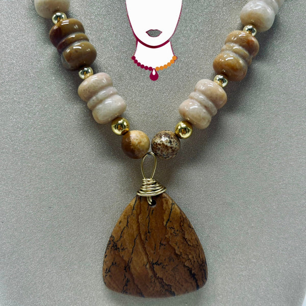 Necklace with brown and beige beads and a large brown pendant on a gray background