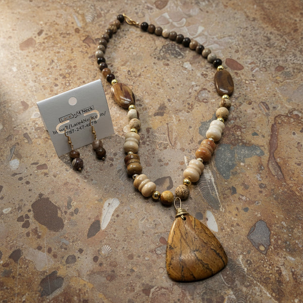 Necklace with brown and beige beads and a large brown pendant on a white background, with a matching earring.