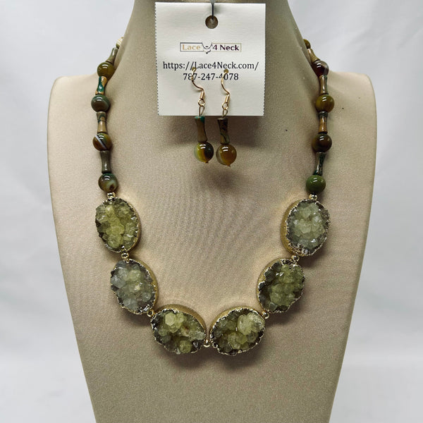 Necklace and earrings set on a mannequin bust with a visible brand tag.