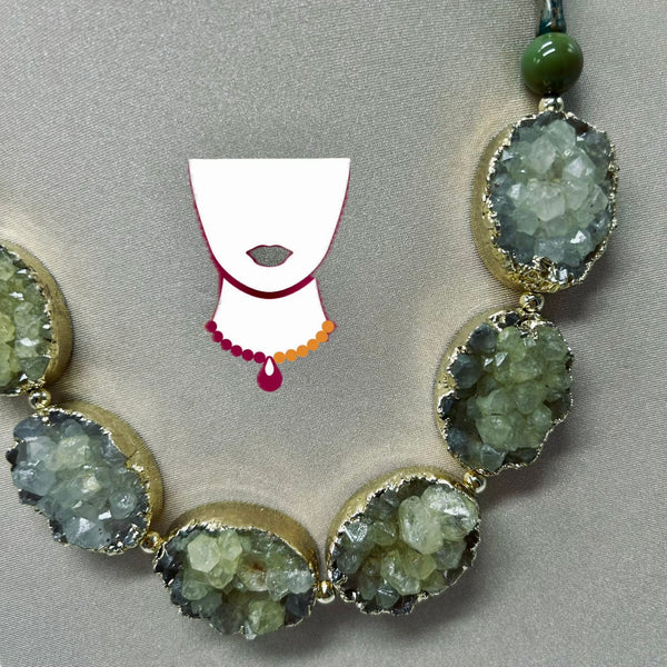 Necklace with green gemstone pendants on a gray background