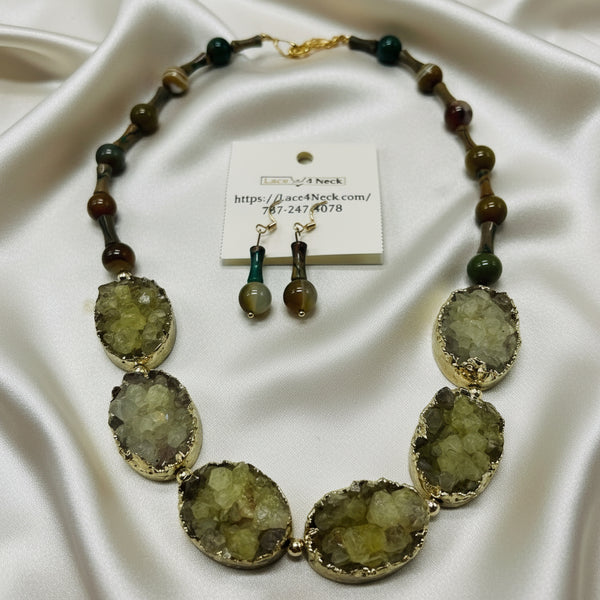 Necklace with green stone beads and matching earrings on a white background