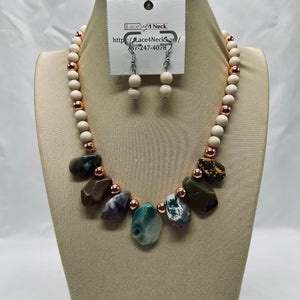Necklace and earrings set on a mannequin bust with a visible brand tag.