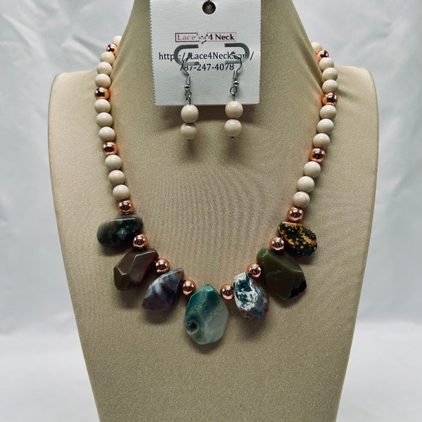 Necklace and earrings set on a mannequin bust with a visible brand tag.