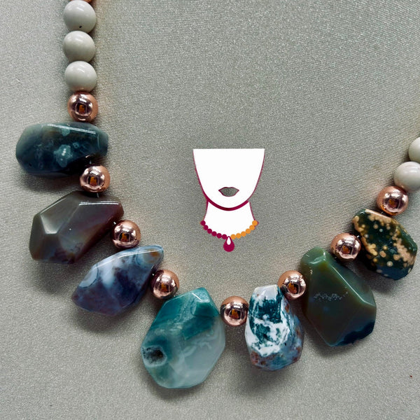 Necklace with natural stone beads on a gray background