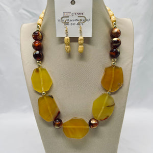 Necklace and earrings set on a mannequin with a visible brand tag.