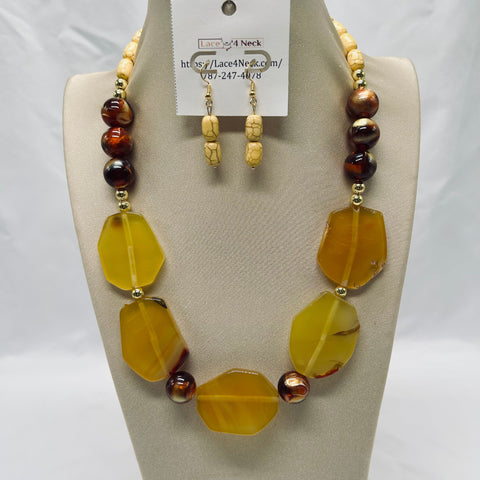 Necklace and earrings set on a mannequin with a visible brand tag.