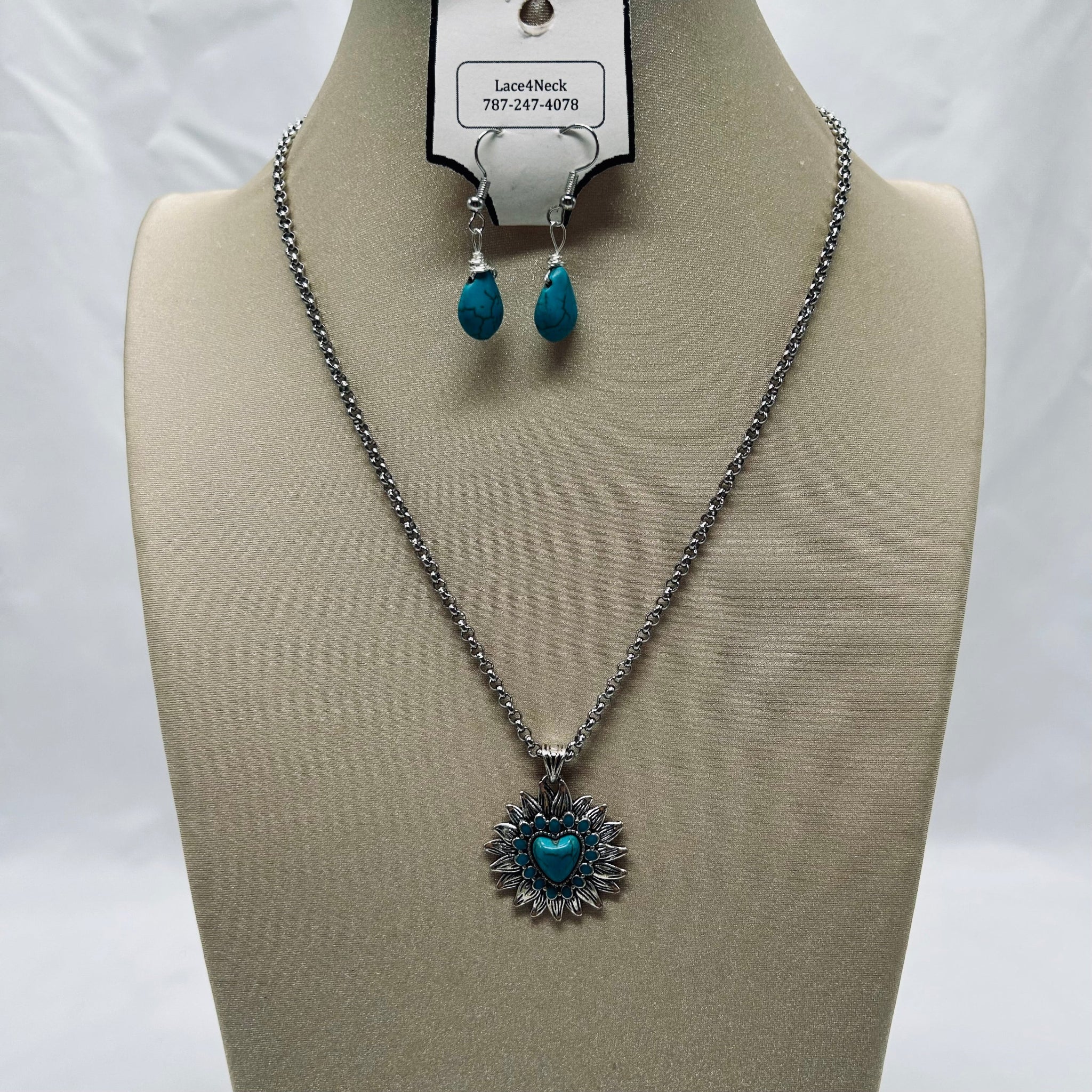 Jewelry set with necklace and earrings on a mannequin bust against a white background